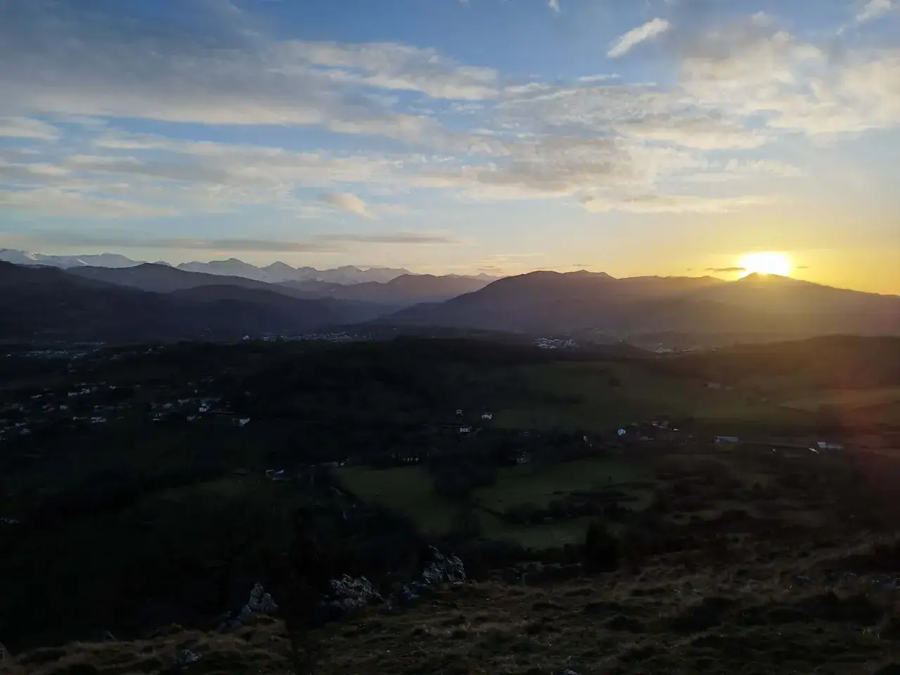 Coucher de soleil sur les Pyrénées depuis le tuc de Montcalivert. Les montagnes enneigées se découpent à l'horizon, baignées par la lumière dorée.