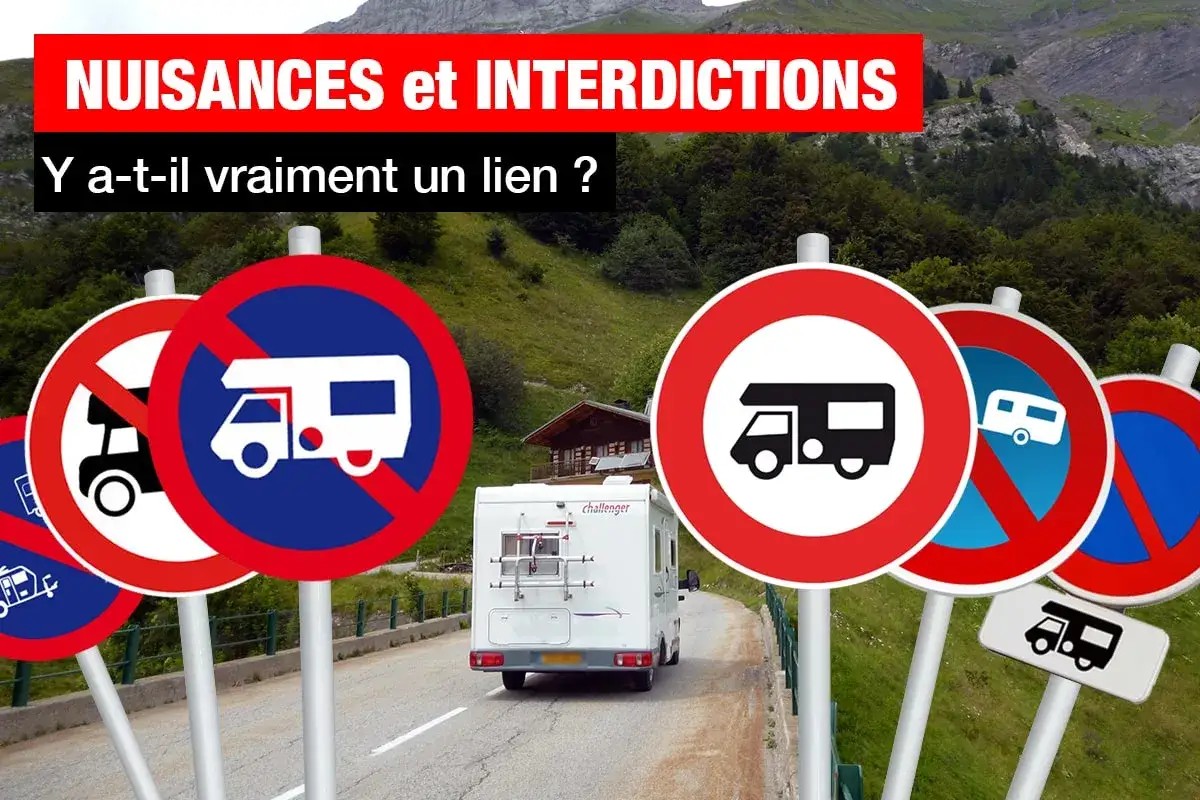 Plusieurs panneaux interdisent le camping-car dans ce paysage montagneux. Un camping-car blanc est garé sur la route.